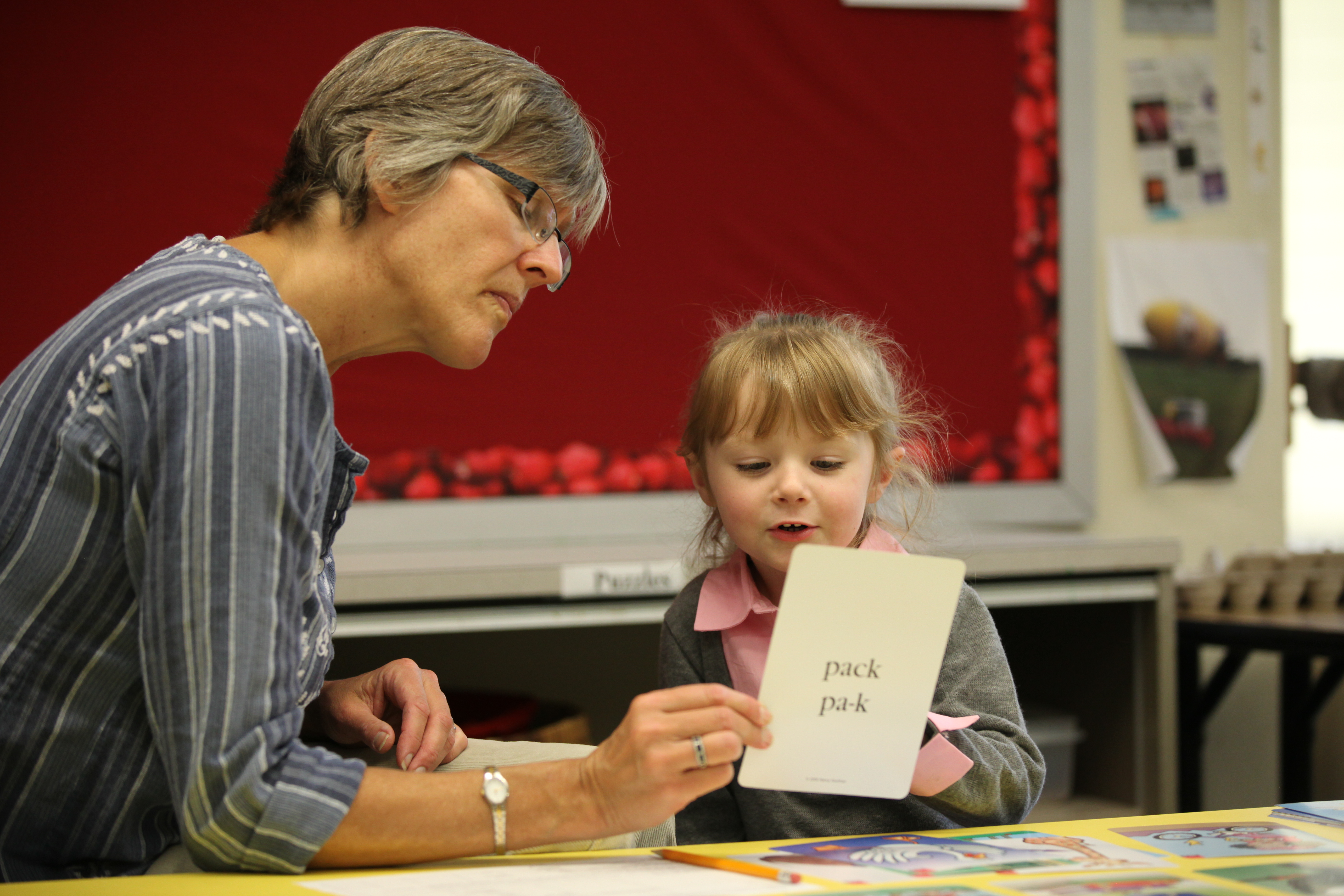 A teacher works with a student in a classroom
