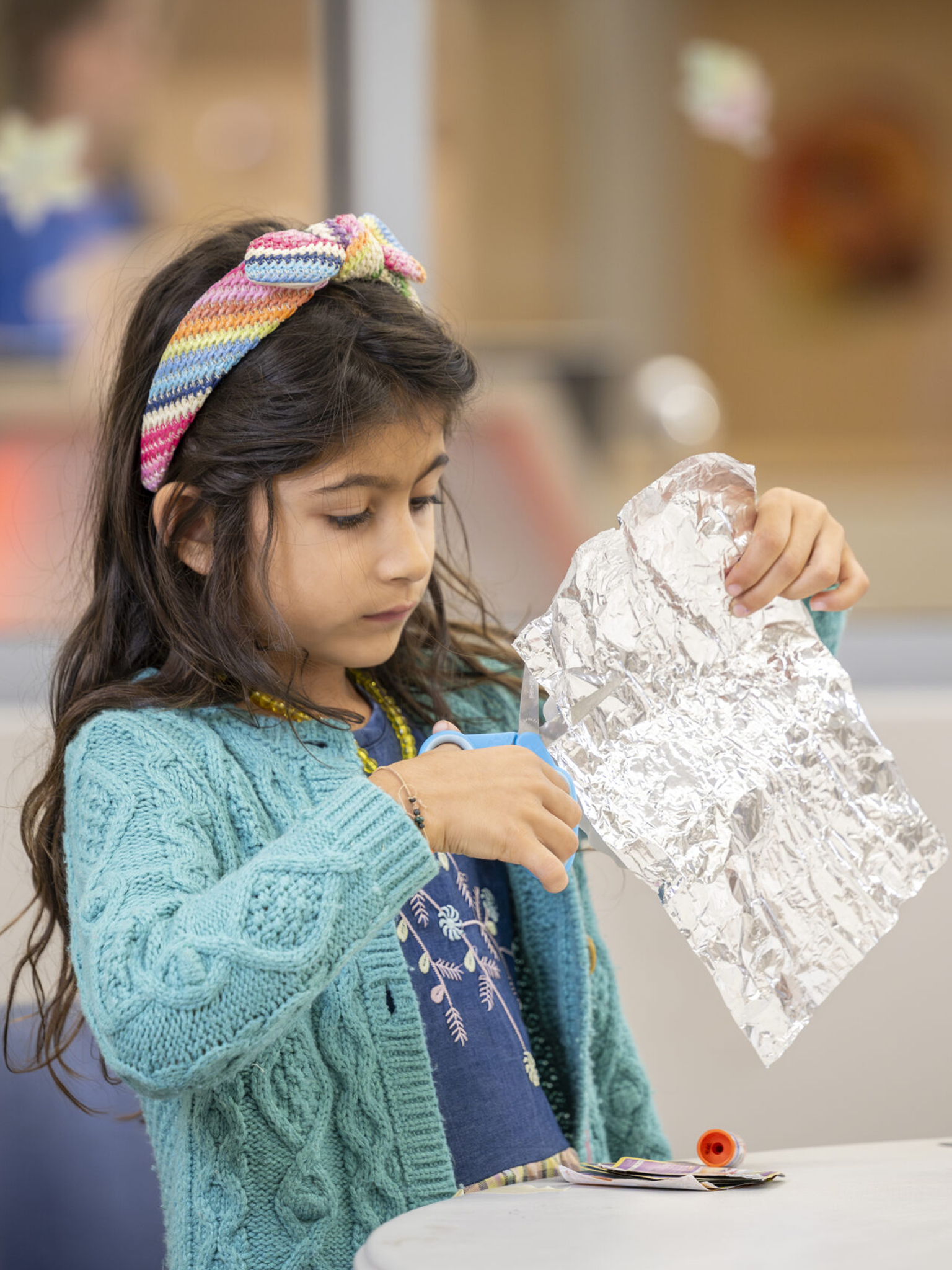 Kid cuts out foil in a classroom