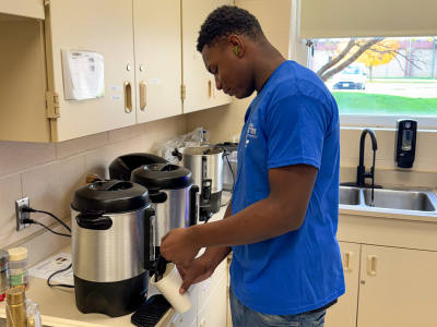 A Brewing Abilities Cafe student prepares coffee