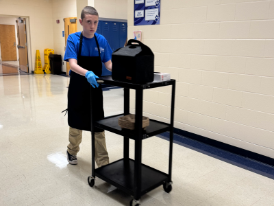 A Brewing Abilities Cafe student delivers coffee