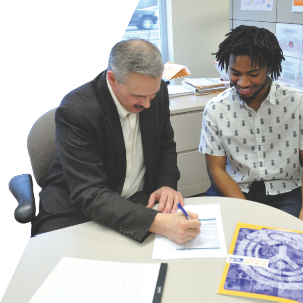 Two individuals sit at a desk and review a document. Photo courtesty of United Way of Summit & Medina